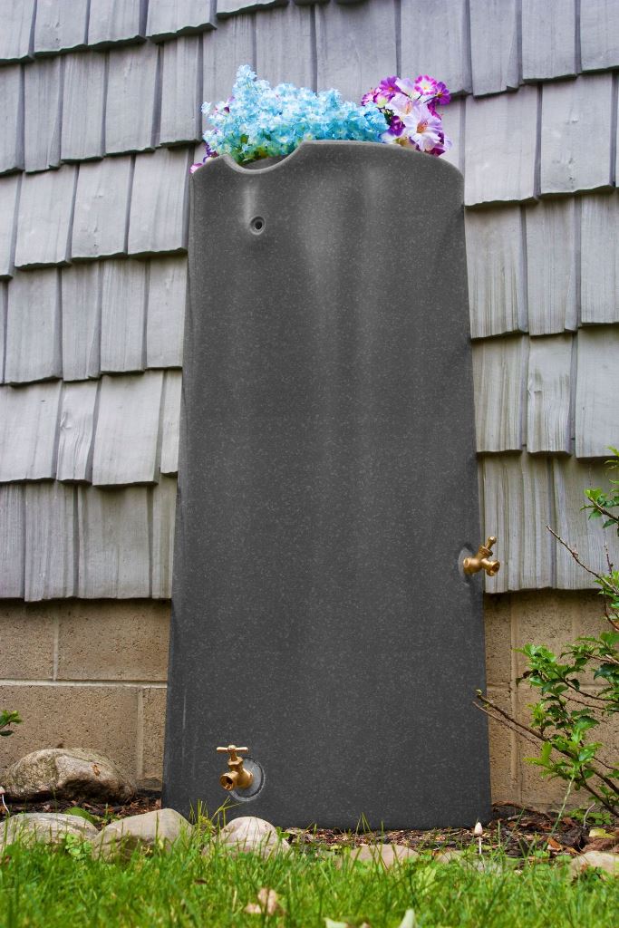This tall grey stone container is styled with bright flowers on top and adds to the exterior of the house.