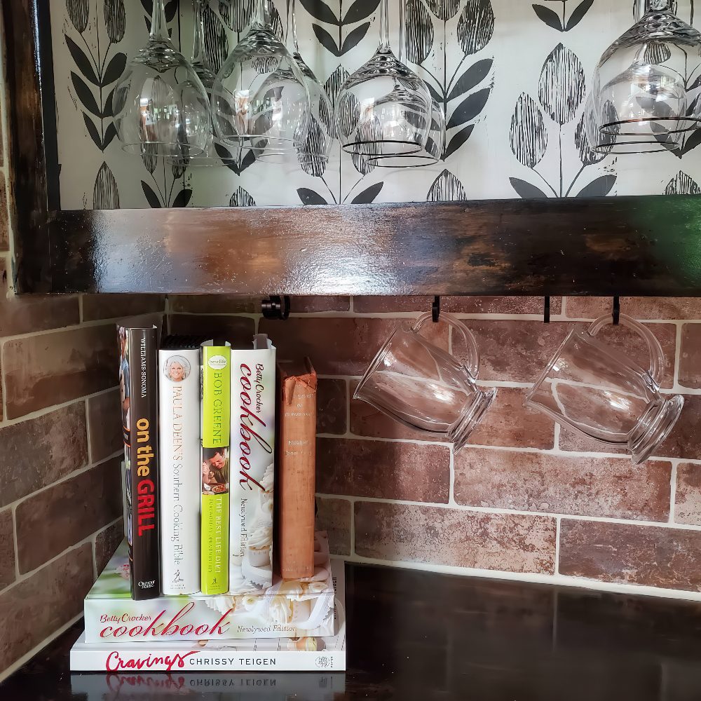 Cookbooks and mugs steal the spotlight while your router hides behind them like a shy guest. Functional, cozy, and no tech eyesore in sight.

(@aton.of.love).