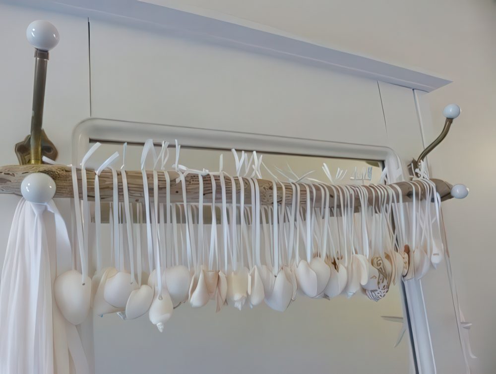 A wooden stick with lots of seashells hanging on it is a cool way to add a coastal feel to the space.