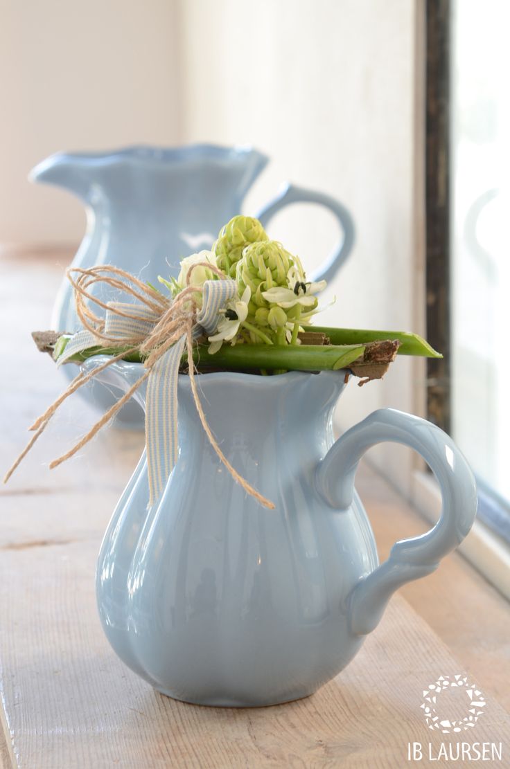 Vintage blue teapots and milkpots with greenery and neutral blooms will give a slight vintage or rustic feel to the space.