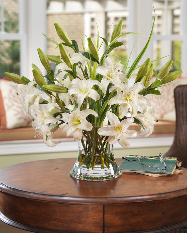 A clear vase with lots of white lilies is an elegant and chic decoration or centerpiece for any party.