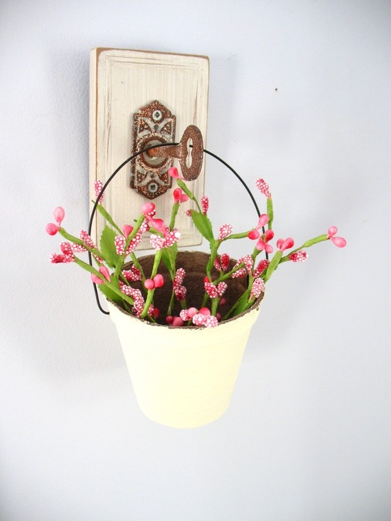 A white bucket with pink blooms hanging on a vintage key is a lovely decoration for both indoors and outdoors.