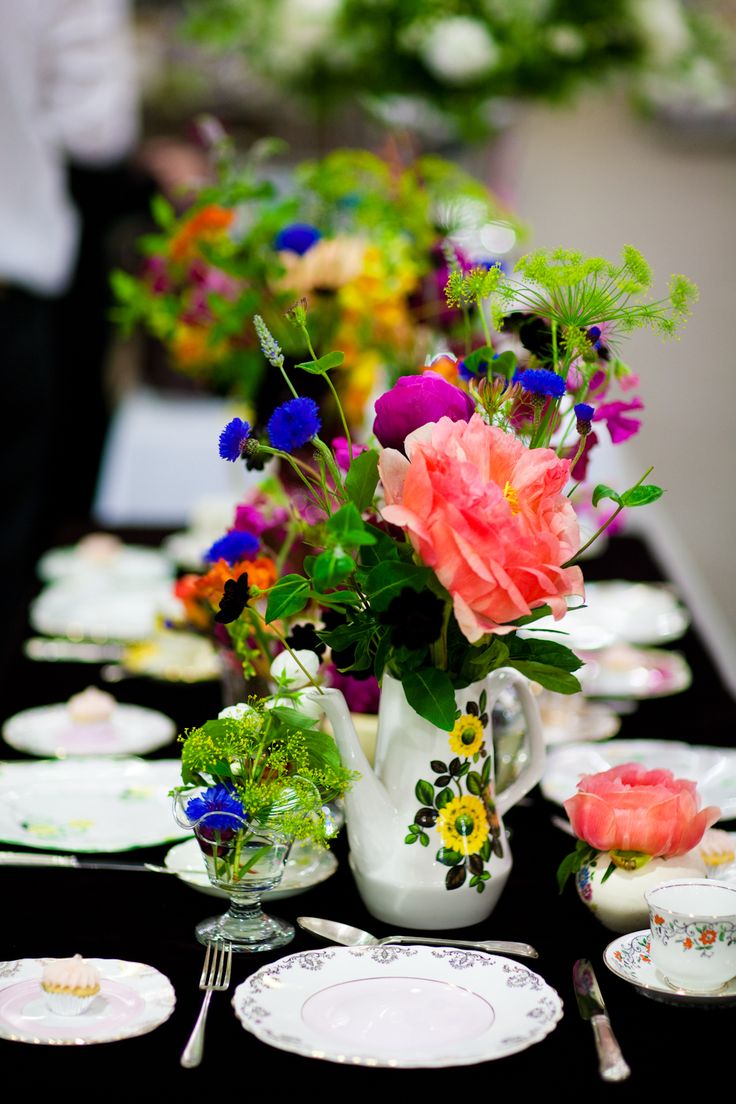 Vintage painted teapots and glasses with super bright blooms and greenery are nice to accent any tablescape.