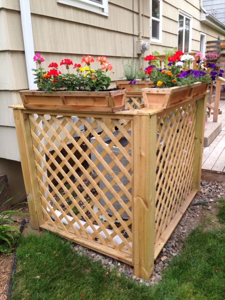 This piece built of lattice screens is topped with planters and bright blooms cheer it up.