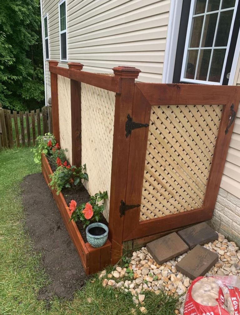 The AC unit is covered with lattice screens in stained frames and it's so large that it requires a door.