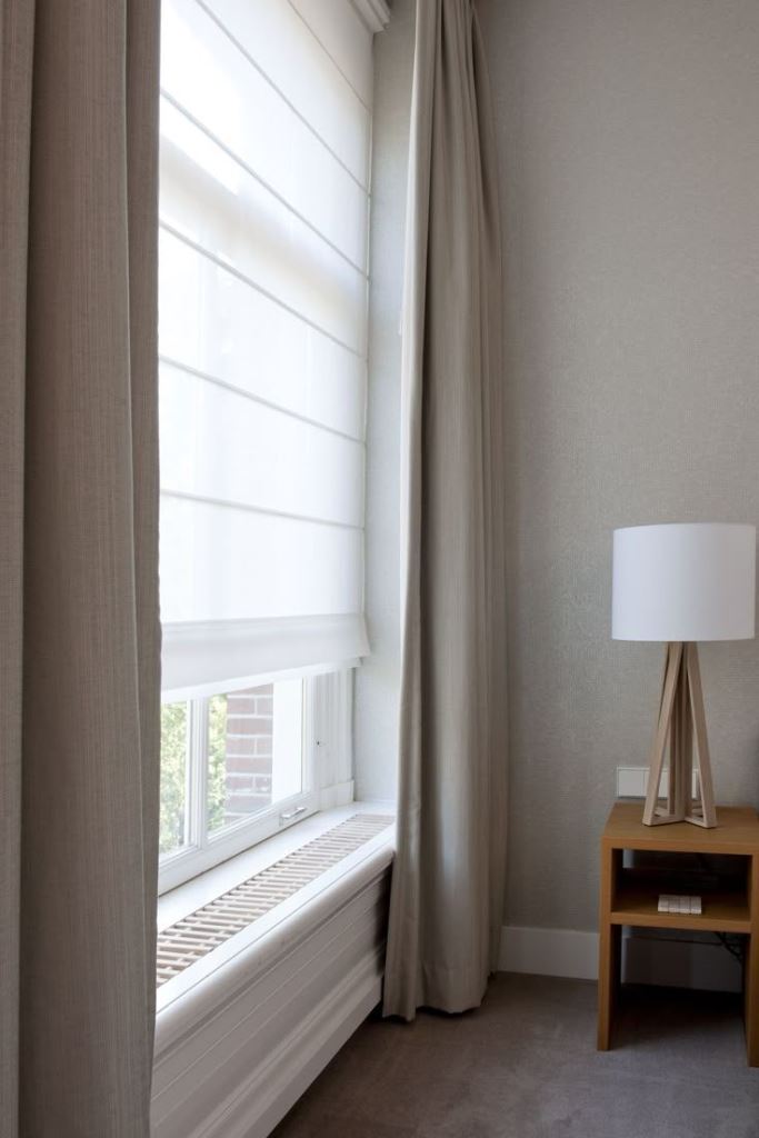 This contemporary space is done with semi-sheer shades and textural drapes that match the interior.