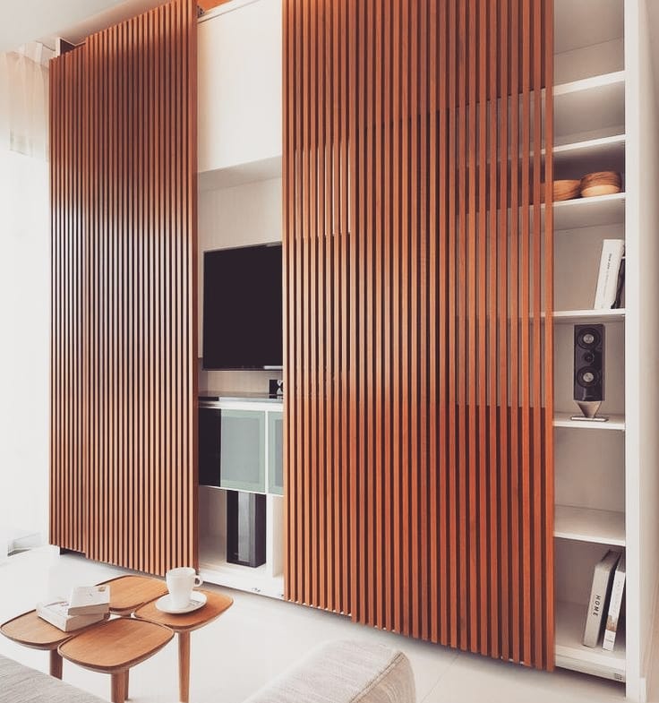 Tucked neatly into a wall of slatted panels, this setup makes your TV just another part of the furniture—literally. Clean, calm, and clever.

(@soh_interiors).