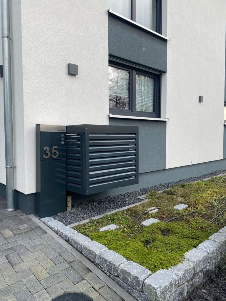 The AC unit attached to the wall is hidden within a black metal box to make a perfect match for the facade.