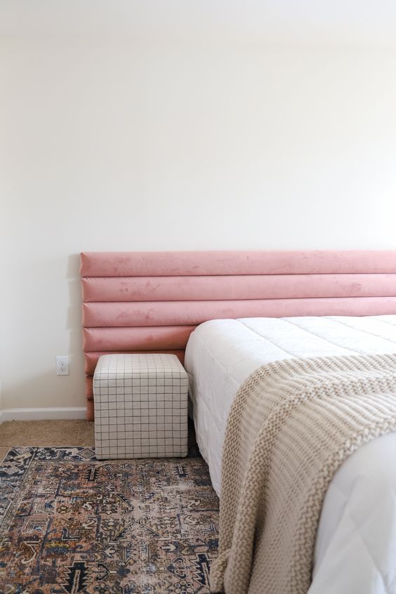 This pastel pink ribbed upholstered headboard is a soft touch of color to the space, and its texture adds even more softness.