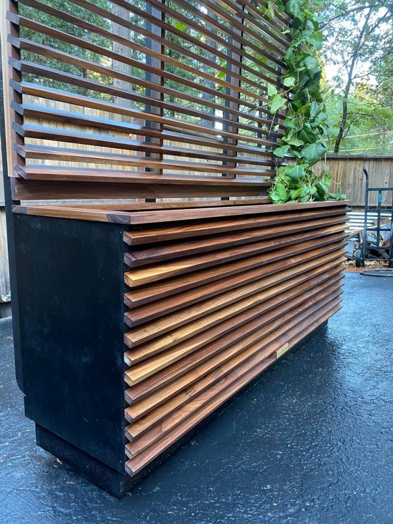 The big slat planter with a trellis and green vines covering it is a lovely solution to divide spaces.