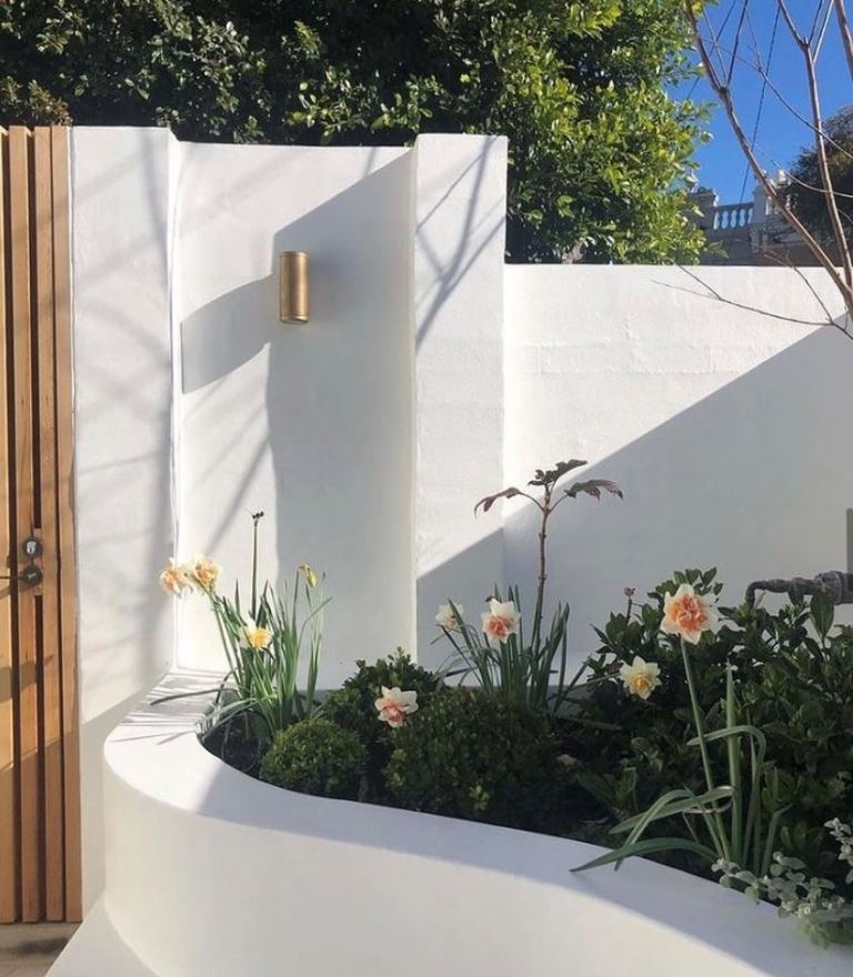 The raised gardenbed with blooms styles the corner of the garden that would otherwise be awkward.