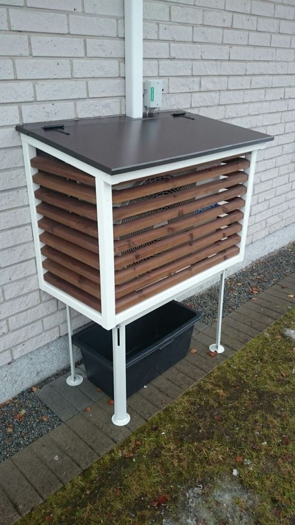 This box raised on legs is made of wooden slats and there's a roof on top to hide the piece from rain.