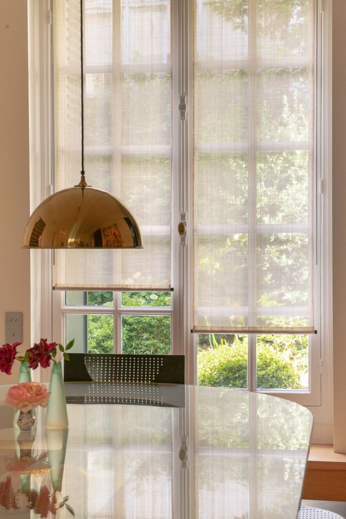 These lovely semi-sheer Roman shades let light in and cover the window to avoid the views.