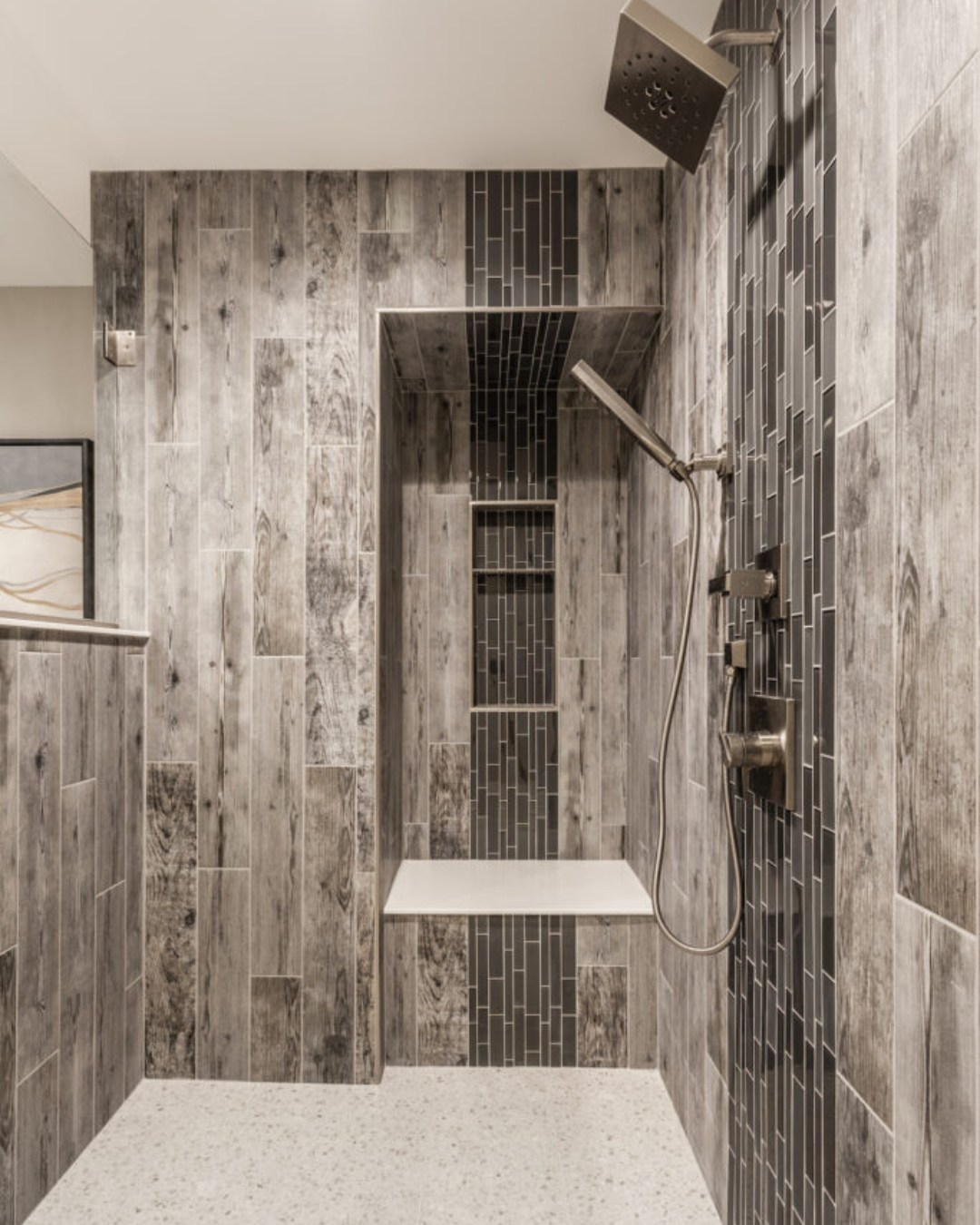 A simple yet effective half-wall design that subtly defines the shower space. It keeps water from splashing everywhere while allowing natural light to flow through. This is a great solution for bathrooms where a full glass enclosure feels too enclosed. (@jgaukerinteriors).