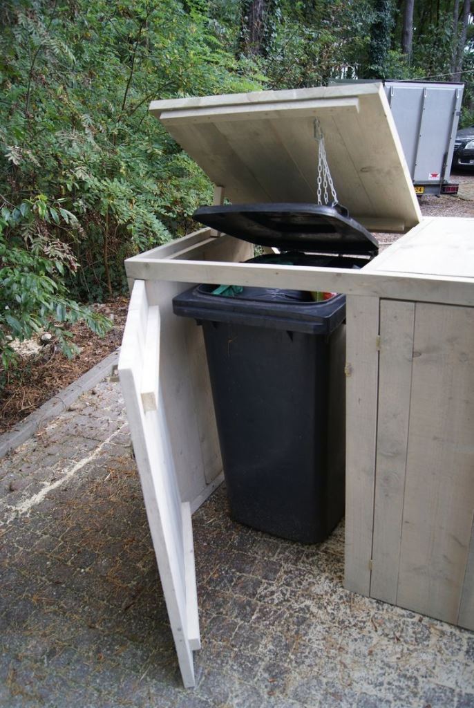 This simple whitewashed wooden box hides a couple of trash cans, and the chains attached to the lid make opening easier.