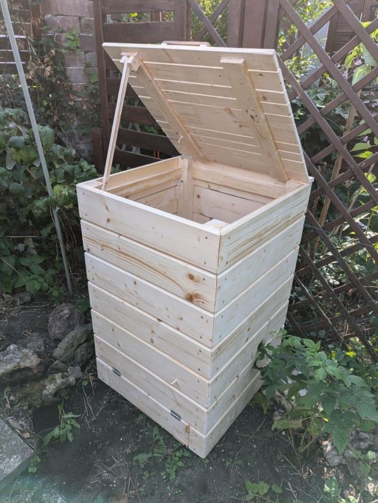 This simple whitewashed wooden box with a lid is for one trash can, and building one is quite easy.