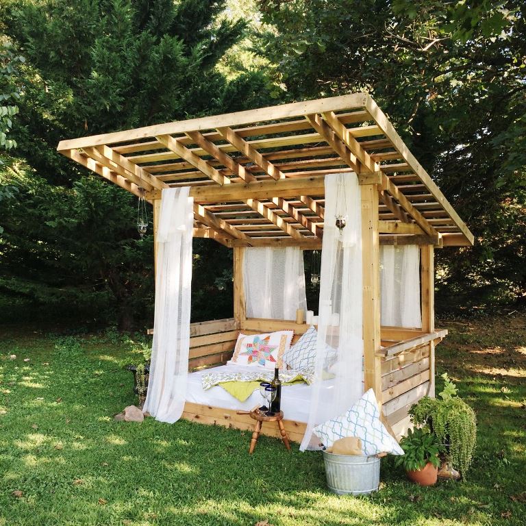 This lovely pergola is an outdoor bedroom with mosquito net curtains that protect from bugs.