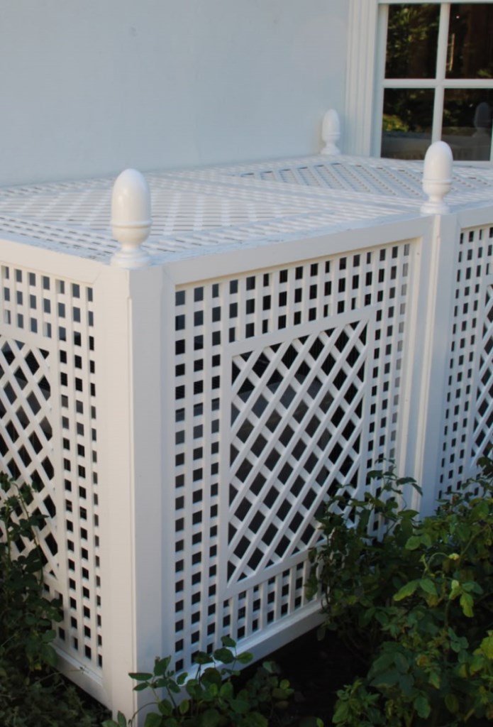 The AC units are hidden with elegant white lattice boxes to match the facade of the house.