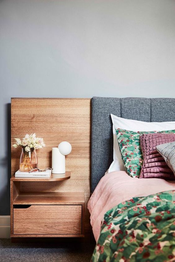 The bedroom is done with a bed with an upholstered headboard and a stained part with a built-in shelf and nightstand.