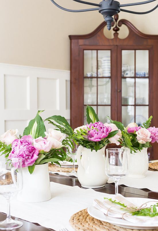 White porcelain milk jugs with hot pink and blush blooms are a lovely rustic summer decoration.