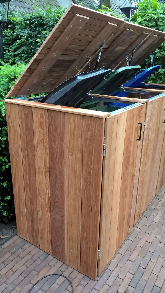 The large stained box for trash cans features a large lid, it's a cool contemporary idea for an outdoor space.